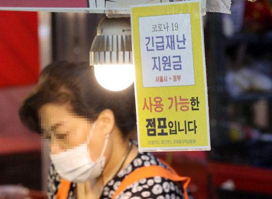 전 국민의 약 88%가 1인당 25만원씩 받는 코로나 상생 국민지원금(재난지원금) 지급 절차가 시작된 6일 서울 마포구 재래시장의 한 가게에 긴급재난지원금 사용 가능 안내 문구가 붙어있다. 연합뉴스